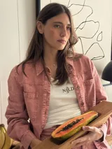 Chaqueta de jean azul, de corte entallado, con cuello camisero, cierre frontal con botones y bolsillos delanteros con solapa.