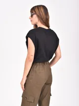 Remera de algodón blanca, de corte holgado y diseño sin mangas con hombros caídos.