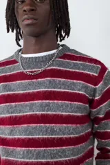Sweater de punto con diseño a rayas horizontales en tonos gris y bordó, de cuello redondo, manga larga y calce relajado.