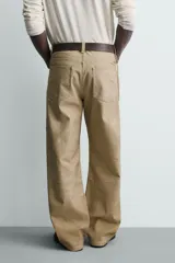 Pantalón straight fit de algodón con efecto lavado y roturas localizadas. Presenta diseño de cinco bolsillos, cierre frontal con cremallera y botón metálico.