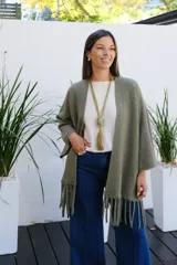 Saco abierto de tejido de punto en color verde oliva, con mangas tres cuartos y detalle de flecos en el ruedo.