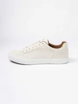 Championes urbanos de diseño minimalista en color beige, con suela de goma blanca y detalles en color marrón en el interior y borde del cuello.