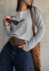 Remera de manga larga a rayas grises y blancas, de tejido acanalado, con cuello redondo y cartera de botones frontal.