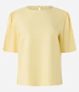 Blusa de viscolino color amarillo pálido, con cuello redondo y mangas cortas abullonadas.