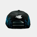 Gorro tipo trucker color negro con paneles frontales de tela y paneles traseros de malla. Presenta un diseño bordado de llamas en color azul que recorre la visera y los laterales, junto con un logo bordado en blanco en el frente.