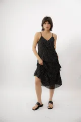 Vestido midi negro con estampado de lunares blancos, escote en V, breteles finos y diseño con volados en capas.
