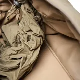 Bolso deportivo de gran capacidad en color verde oliva, confeccionado en material textil con acabado arrugado. Cuenta con doble asa superior, correa ajustable desmontable, compartimento principal con cierre y correas en la base para sujetar accesorios.