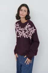 Buzo de punto color bordó con cuello redondo, mangas largas y diseño holgado. Presenta un bordado de hojas en color rosado en la parte superior del pecho.