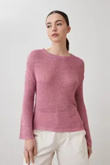 Sweater de punto fino en color verde, con cuello redondo y mangas largas. Presenta un detalle integrado de pañuelo estampado con motivos florales en la parte inferior, que se cruza sobre la cintura.
