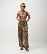 Pantalón ancho de tule con estampado de leopardo, cintura y puños elásticos. El conjunto se compone de un top sin mangas con cuello alto y un pantalón a juego con fajín anudado a la cintura.