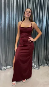 Vestido largo de fiesta color bordó, con escote drapeado, breteles finos cruzados en la espalda y falda con tajo lateral.