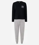 Pijama largo Lov de dos piezas, compuesto por una remera de manga larga y cuello redondo en color negro con estampa localizada en el pecho, y un pantalón con cintura elástica y botamangas ajustadas con estampado a cuadros.