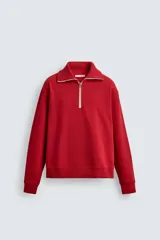 Sudadera de corte regular fit color rojo, con cuello subido y cierre frontal de cremallera. Presenta mangas largas y acabados en rib en puños y ruedo.