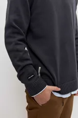Sweater gris oscuro de punto con cuello redondo, manga larga y puños y dobladillo acanalados.