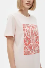 Remera de manga corta color azul con estampa frontal oscura de una ballena decorada con motivos florales.