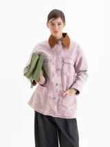 Chaqueta de silueta amplia y relajada con efecto lavado en tono rosado. Presenta cuello de corderoy en contraste, cierre frontal con botones y bolsillos frontales.