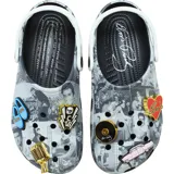 Zuecos tipo Crocs de diseño slip-on, con estampado fotográfico en blanco y negro de Elvis Presley, suela negra, tira trasera blanca pivotante y dijes Jibbitz dorados y de colores en el empeine.