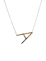 Collar plateado con dije de la letra G mayúscula.