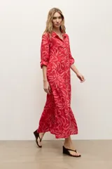 Maxi vestido camisero rojo con estampa floral, cuello camisero, cierre frontal con botones y mangas largas.