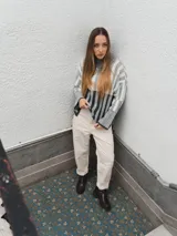 Sweater tejido a rayas horizontales color beige, marrón y negro, de cuello alto y corte holgado.