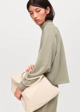 Buzo de cuello perkins y manga larga, confeccionado en tejido de punto suave con diseño recto y holgado.