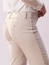 Pantalón de vestir color beige, de corte recto, con bolsillos laterales y traseros. Se ajusta a la cintura con broches internos y cierre.
