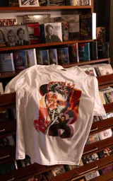 Remera blanca de manga corta y cuello redondo con calce oversize. Presenta un estampado frontal artístico y colorido de David Bowie.