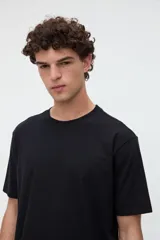 Remera de manga corta básica color negro, confeccionada en jersey de algodón de textura suave, con cuello redondo y calce clásico.