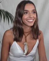 Collar con dije de nácar irregular y tiento de cuero marrón.