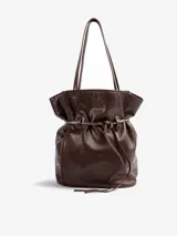 Bolso tipo tote de cuero vacuno marrón, de gran tamaño y diseño liviano. Cuenta con doble asa de hombro y detalle de correa ajustable con nudo en el frente.