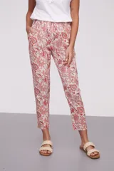 Pantalón de corte recto con estampado floral en tonos coral y verde sobre fondo crudo. Tiene bolsillos laterales y cintura elástica.