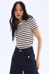 Pantalón de jean azul oscuro, de tiro alto, corte ancho y largo tobillero. Presenta bolsillos delanteros con botón y bolsillos traseros abiertos.