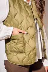 Chaleco verde militar con diseño acolchado y cierre frontal con botones.