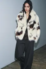 Chaqueta de pelo sintético con estampado animal tipo vaca, cuello solapa, manga larga y forro interior.