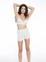 Short de tiro alto con diseño seamless, confeccionado en tejido suave de color beige melange. Presenta una banda elástica en la cintura con detalle de logo pequeño.