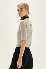 Remera de manga tres cuartos, corte ajustado al cuerpo, con escote redondo amplio. Presenta un patrón de rayas finas horizontales en tonos azul marino y blanco.