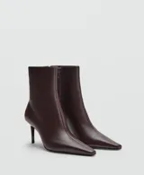 Botin de cuero caprino color marrón oscuro, con diseño de punta fina y tacón kitten de 6,5 cm. Cuenta con cierre de cremallera lateral.