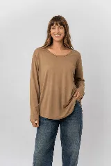 Remera de manga larga en color marrón, de corte relajado, con cuello redondo amplio y dobladillo redondeado.