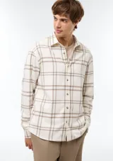 Camisa de franela a cuadros color beige y blanco, de manga larga y cierre frontal con botones.