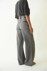 Pantalón de jean con corte baggy de tiro medio, diseño de cinco bolsillos y acabado desgastado en tono gris oscuro.