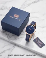 Reloj analógico con caja redonda de metal en tono oro rosa y esfera azul con efecto brillante. Cuenta con una malla de cuero en color azul oscuro y movimiento de cuarzo japonés.
