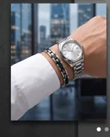 Pulsera de eslabones combinados en acero inoxidable y cerámica negra, con cierre de seguridad.
