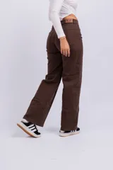 Pantalón marrón de corte wide leg, con bolsillos laterales y traseros.