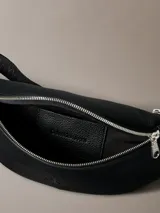 Riñonera negra de poliuretano con cierre de cremallera, correa ajustable y logo de Calvin Klein Jeans en el frente.