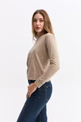 Remera de manga larga en color beige, con cuello redondo y corte recto, confeccionada en algodón.