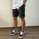 Bermuda de gabardina en color gris oscuro, con corte clásico, bolsillos laterales y cierre frontal.