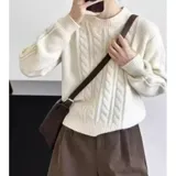 Sweater de punto color blanco marfil, con diseño de trenzas frontales, cuello redondo y mangas largas con puños elásticos acanalados.