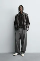 Pantalón de corte balloon fit en color gris, confeccionado en tejido con viscosa. Presenta pliegues frontales, cintura con cinturón integrado a contraste, bolsillos laterales y bolsillos traseros de vivo.