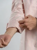 Camisa de corte regular confeccionada en tejido Oxford de algodón, con diseño de rayas verticales finas. Presenta cuello abotonado, cierre frontal con botones y un bolsillo en el pecho.