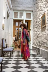 Vestido largo de tul con estampado abstracto en tonos violeta, fucsia, naranja y verde. Sin mangas, con cuello redondo y corte evasé. Incluye una bufanda de tul a juego.